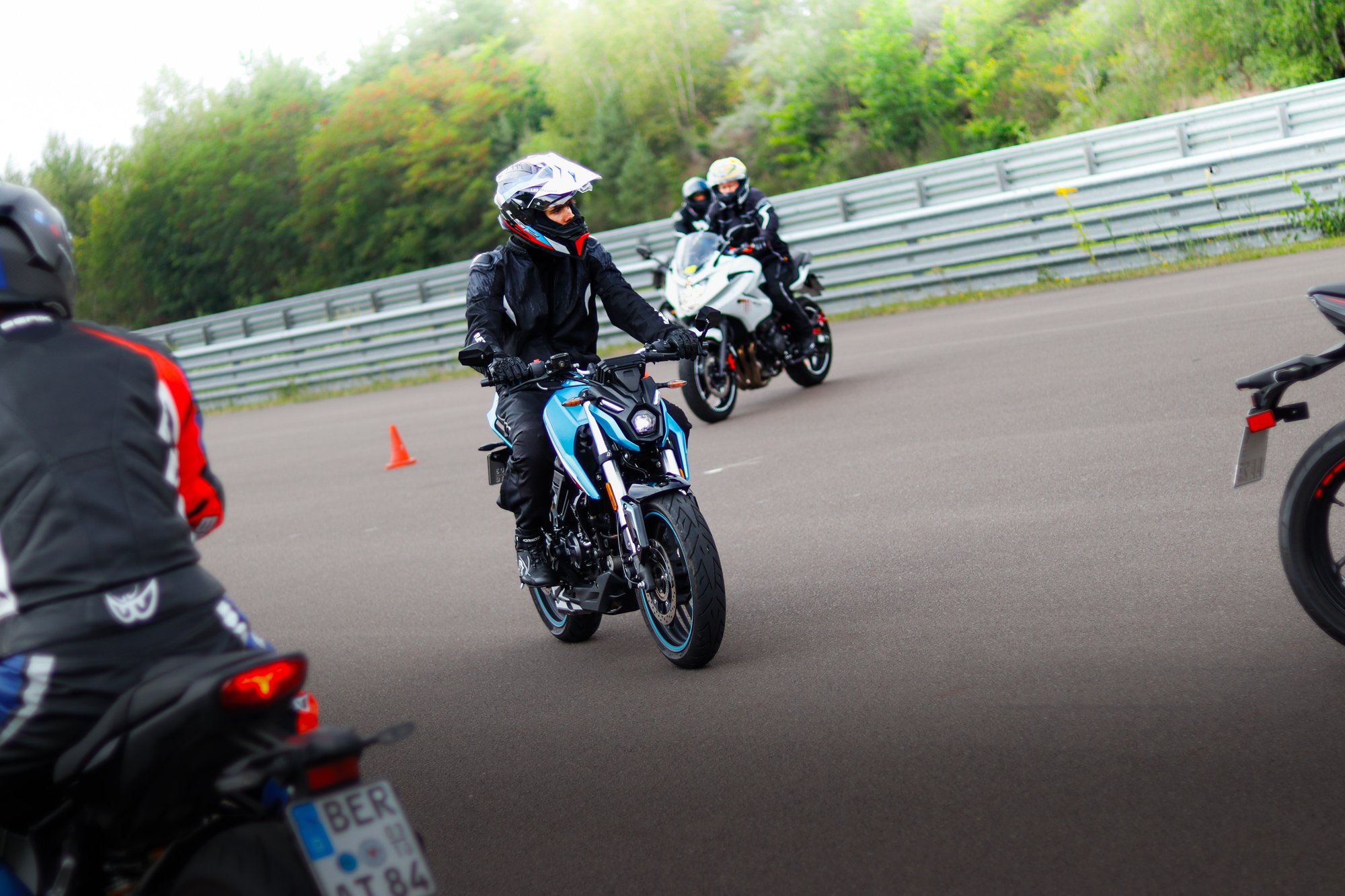 Motorradfahrer im Fahrsicherheitstraining fahren auf dem Übungsplatz an Pylonen vorbei